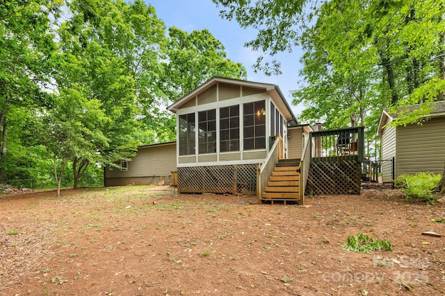 rear view of property with a sunroom, fence, stairway, and a deck