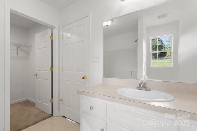 full bathroom featuring walk in shower, visible vents, and vanity