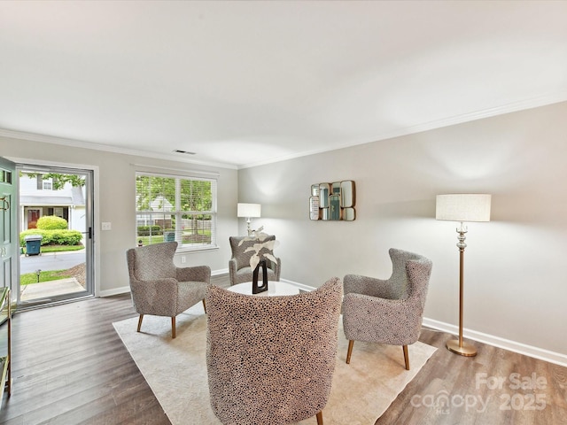 living room featuring ornamental molding, wood finished floors, and baseboards