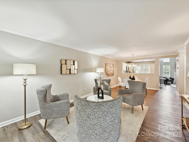 living room featuring crown molding, wood finished floors, baseboards, and a chandelier