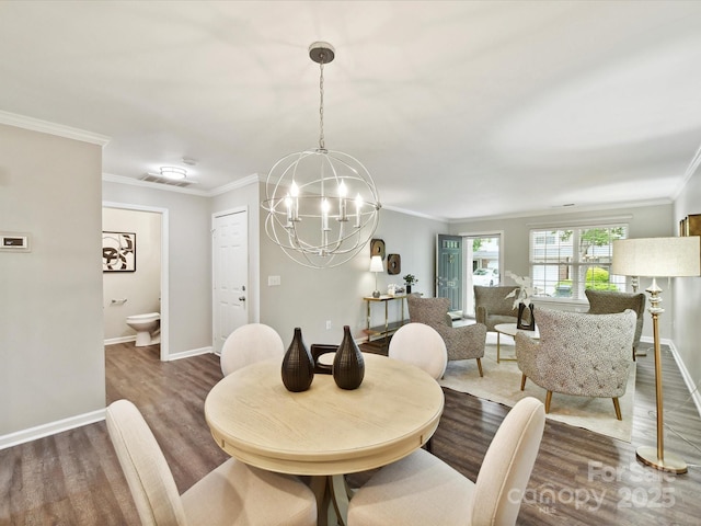 dining space with a chandelier, wood finished floors, ornamental molding, and baseboards