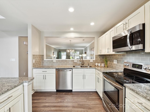 kitchen with stainless steel appliances, a sink, dark wood-type flooring, white cabinetry, and recessed lighting