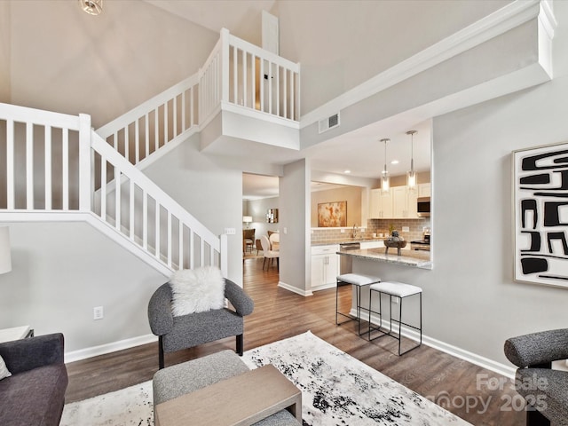 living area with wood finished floors, stairway, baseboards, and recessed lighting