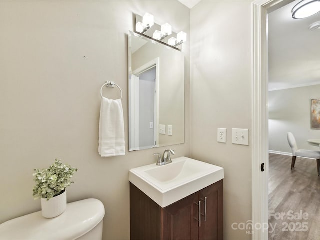 bathroom with vanity, wood finished floors, and toilet