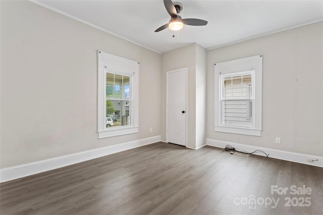 spare room with baseboards, wood finished floors, ceiling fan, and crown molding