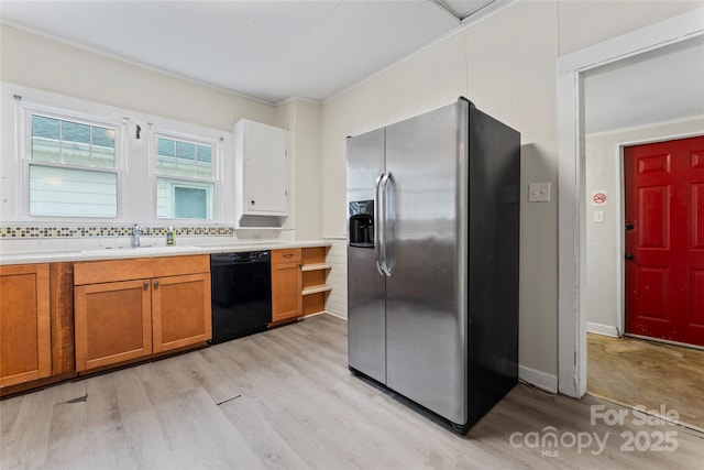 kitchen featuring black dishwasher, stainless steel fridge with ice dispenser, brown cabinets, light countertops, and a sink