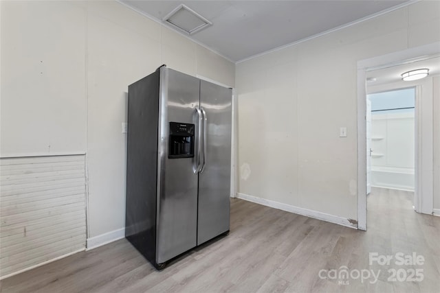 kitchen with ornamental molding, stainless steel fridge, light wood-style flooring, and baseboards
