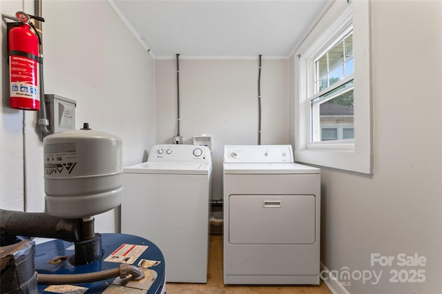 clothes washing area with crown molding, washing machine and clothes dryer, laundry area, and a heating unit