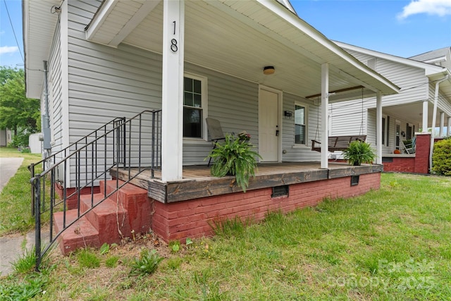 rear view of property with a lawn and a porch