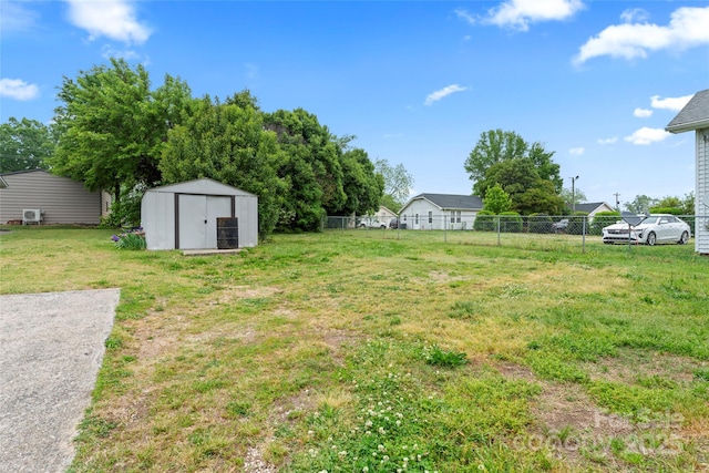 view of yard with an outdoor structure, a shed, and fence