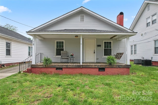 view of front facade with a front yard, central AC unit, and a porch