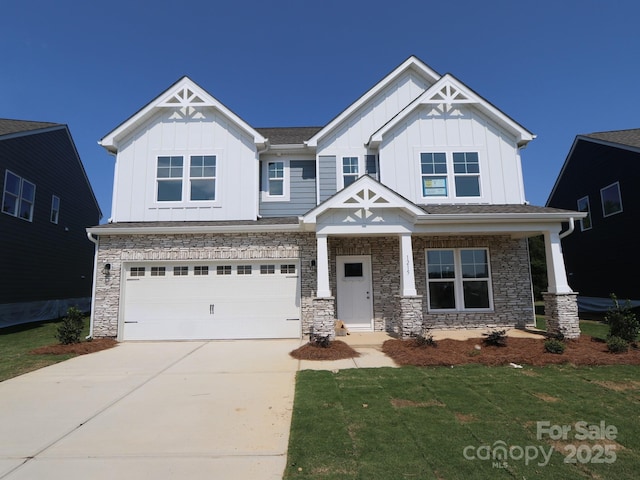 1215 Fremont Dr, Wingate, NC 28174 - craftsman-style home featuring board and batten siding, an attached garage, concrete driveway, stone siding, and a front yard