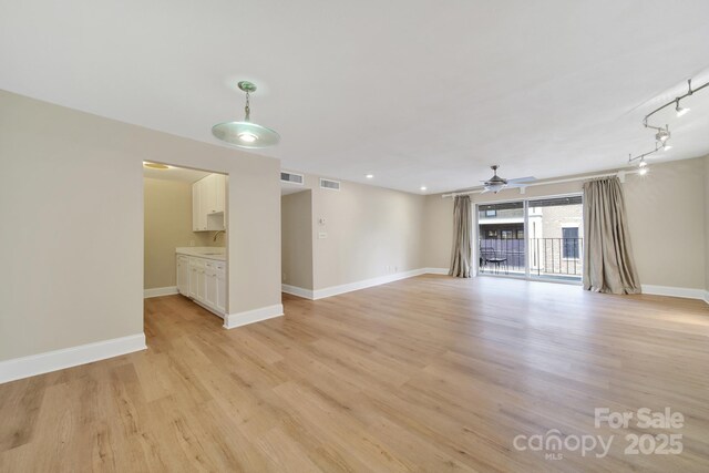 1323 Queens Rd Unit 420, Charlotte, NC 28207 - unfurnished living room featuring visible vents, a ceiling fan, light wood-style flooring, and a sink