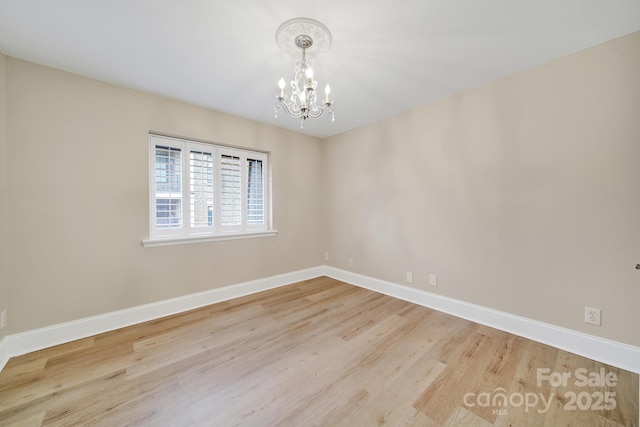 1323 Queens Rd Unit 420, Charlotte, NC 28207 - spare room featuring a chandelier, baseboards, and wood finished floors