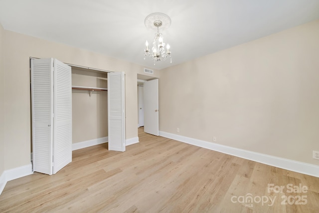 1323 Queens Rd Unit 420, Charlotte, NC 28207 - unfurnished bedroom with a chandelier, a closet, light wood-type flooring, visible vents, and baseboards