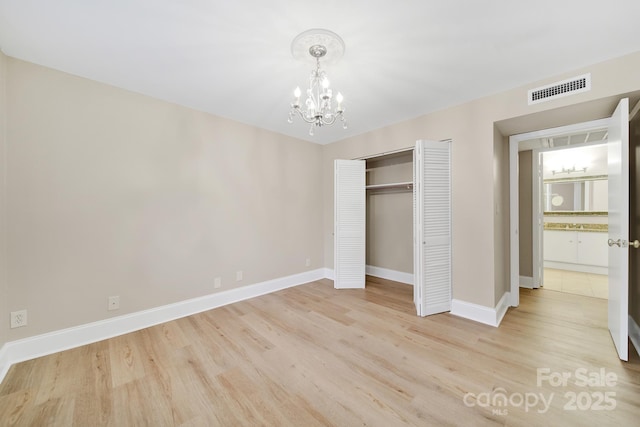 1323 Queens Rd Unit 420, Charlotte, NC 28207 - unfurnished bedroom with a closet, light wood finished floors, baseboards, visible vents, and a notable chandelier
