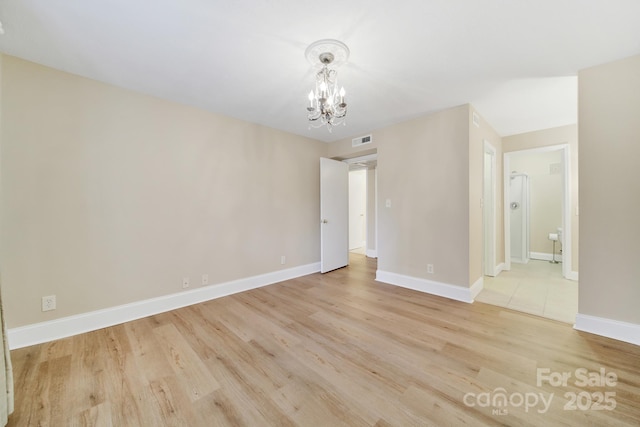 1323 Queens Rd Unit 420, Charlotte, NC 28207 - unfurnished room featuring light wood-type flooring, visible vents, an inviting chandelier, and baseboards