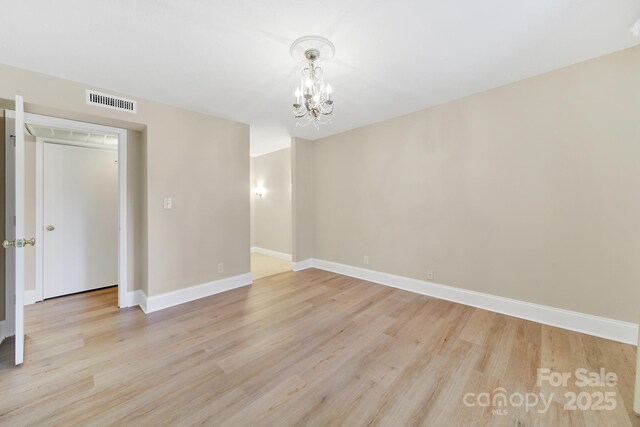 1323 Queens Rd Unit 420, Charlotte, NC 28207 - unfurnished room with visible vents, an inviting chandelier, baseboards, and light wood-type flooring