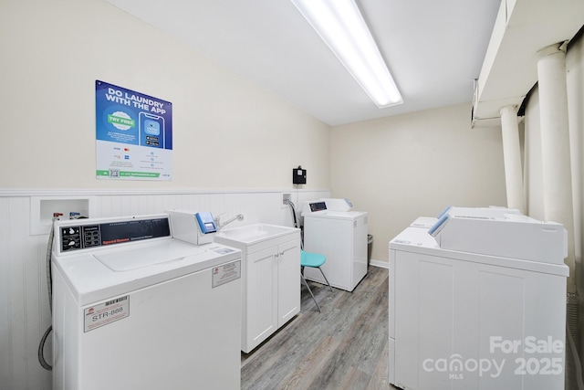 1323 Queens Rd Unit 420, Charlotte, NC 28207 - common laundry area featuring independent washer and dryer, a wainscoted wall, and light wood-style floors