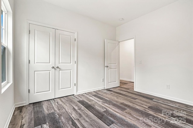 3567 Farmfield Dr, Claremont, NC 28610 - unfurnished bedroom with baseboards, multiple windows, wood finished floors, and a closet