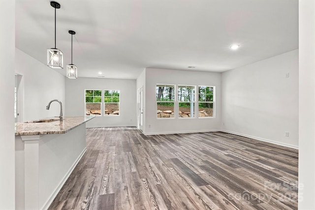 3567 Farmfield Dr, Claremont, NC 28610 - unfurnished living room with recessed lighting, baseboards, dark wood-style floors, and a sink