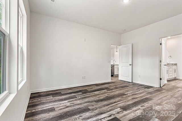 3567 Farmfield Dr, Claremont, NC 28610 - unfurnished bedroom with baseboards, ensuite bathroom, and dark wood-style flooring