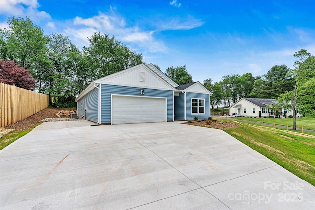 3567 Farmfield Dr, Claremont, NC 28610 - view of front of house with concrete driveway, an attached garage, fence, and a front yard