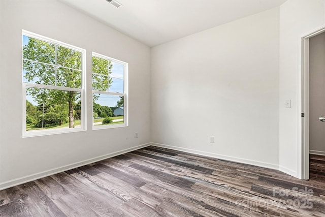 3567 Farmfield Dr, Claremont, NC 28610 - unfurnished room featuring dark wood-style flooring, baseboards, visible vents, and a healthy amount of sunlight