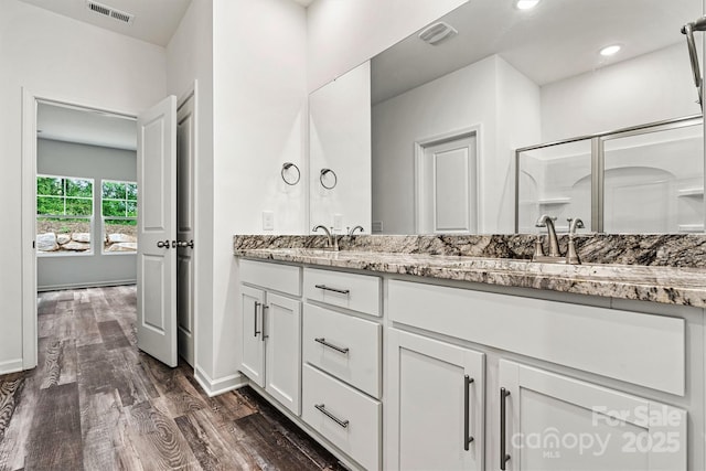 3567 Farmfield Dr, Claremont, NC 28610 - full bathroom with visible vents, double vanity, wood finished floors, baseboards, and a sink