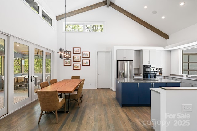 kitchen featuring high vaulted ceiling, dark wood-type flooring, a kitchen island, stainless steel refrigerator with ice dispenser, and beamed ceiling