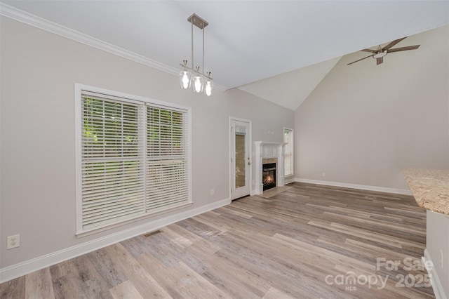 1033 Marguerite Dr, Lowell, NC 28098 - unfurnished living room featuring a ceiling fan, a fireplace with flush hearth, light wood-type flooring, baseboards, and ornamental molding
