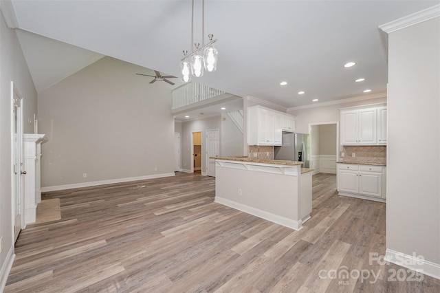 1033 Marguerite Dr, Lowell, NC 28098 - kitchen featuring stainless steel fridge with ice dispenser, white cabinetry, a ceiling fan, open floor plan, and tasteful backsplash