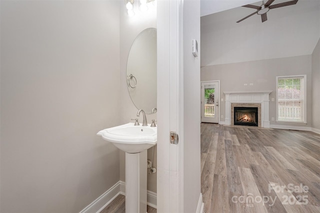 1033 Marguerite Dr, Lowell, NC 28098 - bathroom featuring a fireplace, ceiling fan, baseboards, and wood finished floors