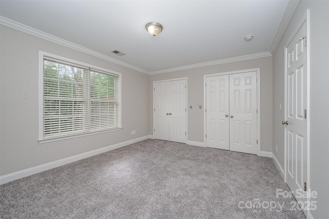 1033 Marguerite Dr, Lowell, NC 28098 - unfurnished bedroom with visible vents, ornamental molding, multiple closets, carpet floors, and baseboards