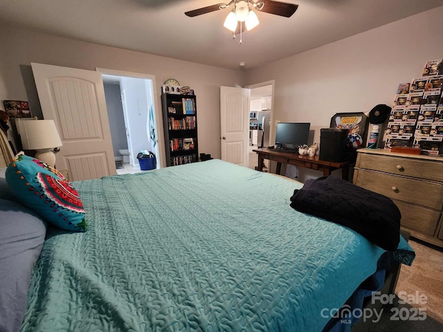 carpeted bedroom with ensuite bathroom and ceiling fan
