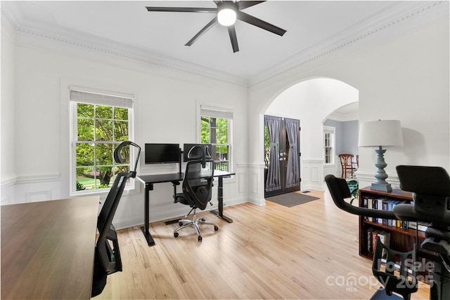 office area featuring a wainscoted wall, ornamental molding, and arched walkways