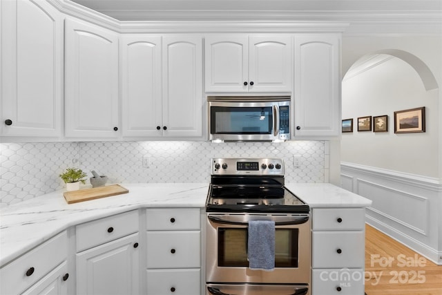 kitchen featuring light stone countertops, white cabinets, and stainless steel appliances