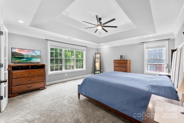 carpeted bedroom with ornamental molding, ceiling fan, baseboards, and a tray ceiling