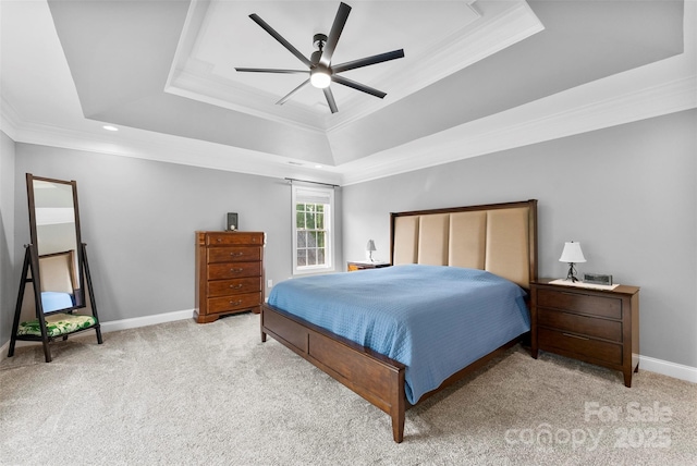 carpeted bedroom with ornamental molding, a ceiling fan, a tray ceiling, and baseboards
