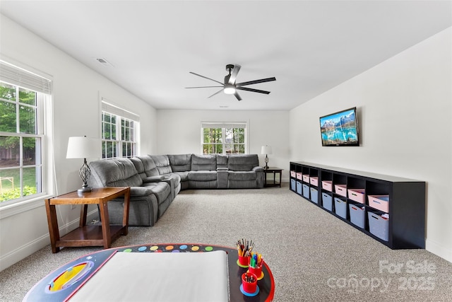 carpeted living area featuring baseboards, visible vents, and a ceiling fan
