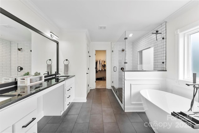 bathroom featuring a shower stall, crown molding, a freestanding tub, tile patterned floors, and vanity