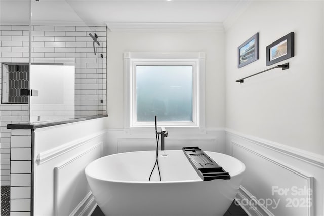 full bathroom featuring ornamental molding, a wainscoted wall, a freestanding bath, and tiled shower