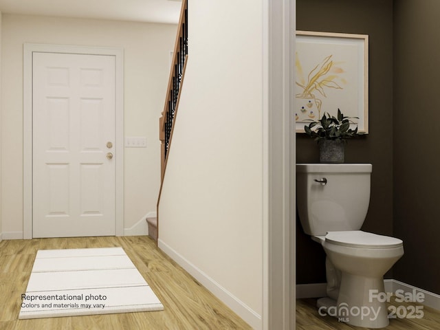 interior space with baseboards, stairway, and wood finished floors