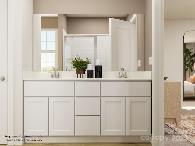 bathroom featuring double vanity, a shower, and a sink