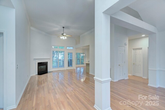 3226 Chatfield Ln SW, Concord, NC 28027 - unfurnished living room with baseboards, light wood-style floors, a ceiling fan, crown molding, and a fireplace