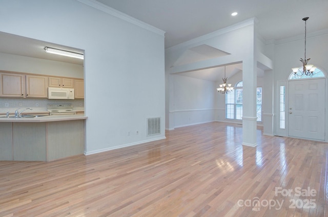 3226 Chatfield Ln SW, Concord, NC 28027 - unfurnished living room with a sink, a chandelier, light wood finished floors, ornamental molding, and visible vents