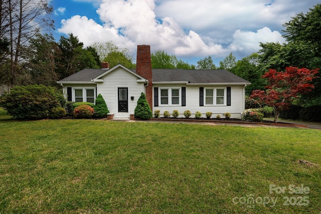 ranch-style house featuring a chimney and a front yard