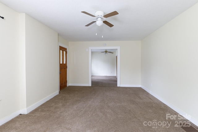 spare room featuring a ceiling fan, baseboards, and carpet