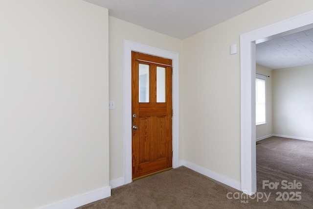 carpeted foyer entrance featuring baseboards
