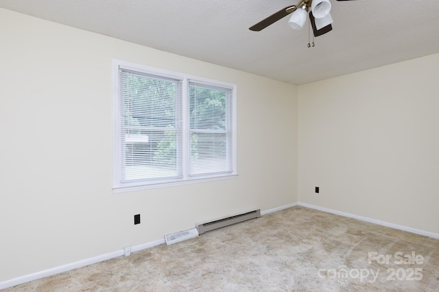 carpeted spare room with a baseboard radiator, visible vents, a ceiling fan, and baseboards